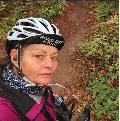 Lisa Graham on a wooded trail wearing a cycling helmet